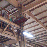 工場内で使われる垂直リフト「マイティパワー TF」の荷台が旋回して荷物を取り込んでいる