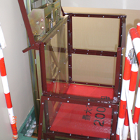 垂直リフト「マイティパワー TF」の荷台をガラス板で囲って安全対策を施している