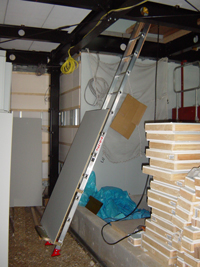 B荷台を利用して建築中の家屋内で天井裏にボードを運び揚げるのに使用されているらくらくリフトJA